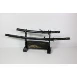 A modern black Japanese Katana Stand, with gilt decoration, and with two Japanese Katana Swords,