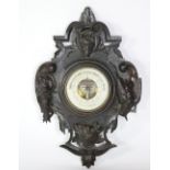 A carved and stained oak "Black Forest" type Aneroid Barometer, decorated with dog and wolf,