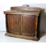 A stained oak Side Cabinet, with shaped back, over two panel doors, flanked by pillar supports,