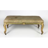 A Victorian period giltwood Window Stool, covered in cream material on cabriole legs,
