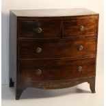 A Georgian period bow fronted mahogany Chest with inlaid and crossbanded top over two short and two