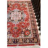 An attractive Turkish red ground Carpet, with rosette centre and floral corners,