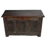 A small panelled carved oak Chest or Coffer, 18th Century or earlier, with stump feet, approx.
