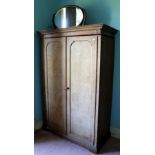 A Victorian bleached oak Wardrobe, together with a large oval mahogany Dressing Table Mirror.