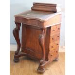 A Victorian walnut Davenport, the scroll carved front with four side drawers, wooden handles,