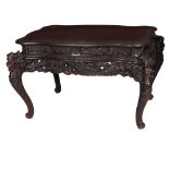 A late 19th Century Chinese Dragon Table, the shaped top with trellis type border,