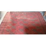 A red ground woolen Carpet, with multiple lozenge central design and slim border, approx.