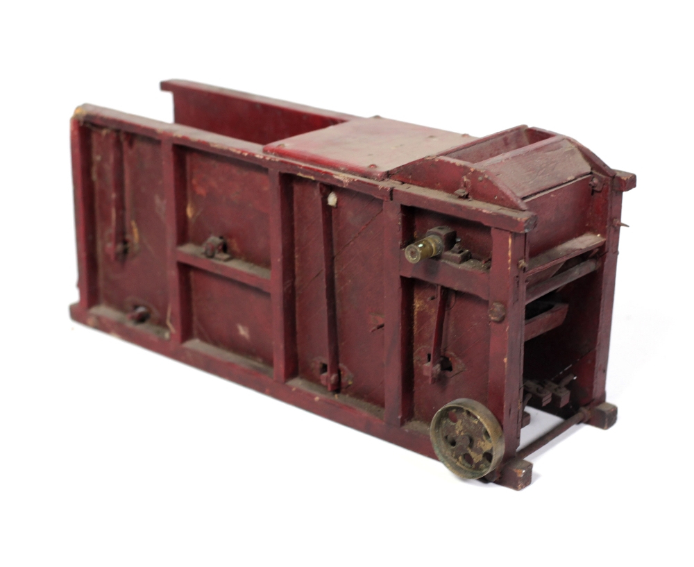 A 19th Century Scale Model of a Thresher, painted red with mechanism.