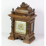An Edwardian carved walnut Mantle Clock, the square brass dial with silver chapter ring,