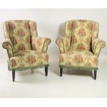 A pair of Edwardian Easy Armchairs, covered in cream ground and colourful floral fabric,