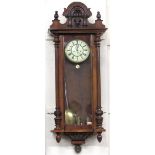 A 19th Century walnut Vienna Wall Clock, the top with carved central mask, Roman numeral dial,