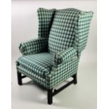 A Georgian style mahogany wing back Armchair, covered in green tartan cloth.