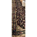 A large antique Oriental Runner, the dark blue ground centre with multiple designs,