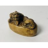 A carved Chinese hard stone Seal, surmounted with a dragon on oval base with character mark on base,