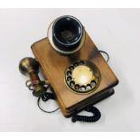 A wall mounted Telephone, with spin dial and lift up receiver.