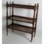 A 19th Century stained oak three tier Dumbwaiter, on pillar supports terminating on castors.