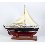A Model Ship, 'Rosses Lass', painted red and black with cream sails.