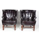 A pair of attractive 20th Century dark brown hide covered deep button wing back "Club" Chairs.