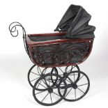 A Victorian style wooden framed and wrought iron Child's Pram, with folding hood and spoked wheels.