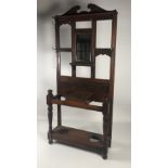 An Edwardian oak Stick and Umbrella Hall Stand, with mirror back and brass hooks.
