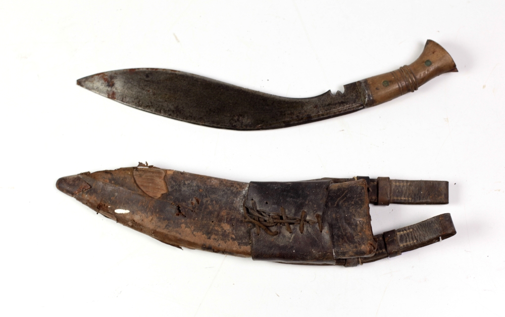 An early 20th Century Kurkha, with shaped blade stamped 1915, with wooden handle and scabbard.