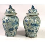 A pair of 18th style Chinese blue and white bulbous Vases and Covers, surmounted with Dogs of Foo,
