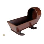 A Victorian mahogany arched and shaped Child's Play Rocking Cradle, with some miniature dolls.