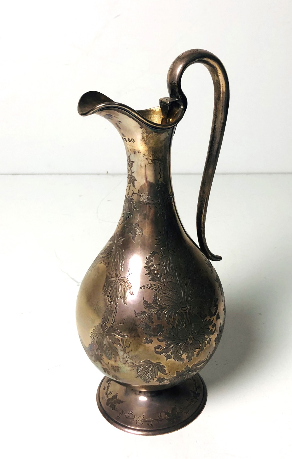 An attractive Victorian English silver Claret Jug, with engraved floral and vine decoration,