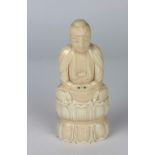 A well carved 19th Century ivory Buddha, seated on a lotus leaf double cushion, 15cms (6") high.