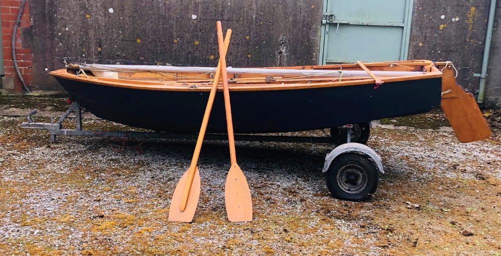 A 11' Mirror Sailing Boat, with sails, oars, canvas cover, and a two wheel trailer.