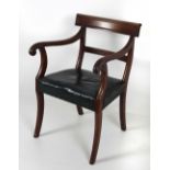 A 19th Century Regency style Carver Armchair, leather covered seat on front sabre legs.
