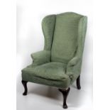 A 20th Century wing back Armchair, in green upholstery,