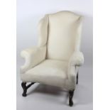 A heavy antique wing back Armchair, on turned H shaped stretcher, and carved front legs.