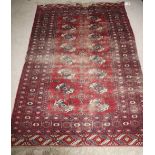 An attractive Middle Eastern red ground Carpet, with 16 lozenge centre and multiple border, approx.