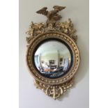 A late Regency period gilt framed Convex Mirror, with carved eagle surmounted,
