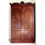 A Victorian figured mahogany two door Wardrobe, with attractive carved canopy. (1) N.B.: approx.