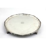 An Edwardian silver Salver, with shaped and moulded edge on scroll feet, by G.H.