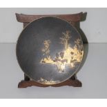 A small black ground circular Japanese metal Plate, with attractive gilt landscape scene,