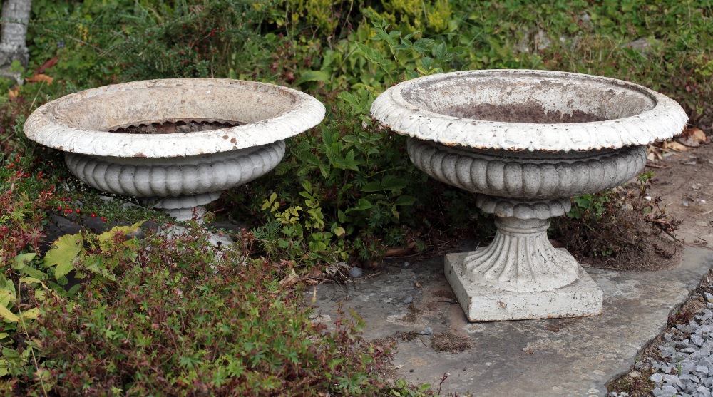 A pair of Victorian cast iron Garden Urns, with egg n' dart moulded rim, on square plinth base,