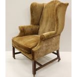 A 19th Century mahogany framed wing back Armchair, covered in fawn fabric,