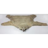 Taxidermy: A rare early model Polar Bear Skin Rug, with head, (some damage) as is, w.a.f. approx.