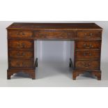 A Georgian style walnut leather top kneehole Desk, the frieze with three drawers,