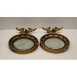 A pair of Regency style eagle surmounted giltwood Convex Mirrors.