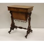 A Victorian walnut lift top Ladies Work Table, with carved and pierced decorated uprights,