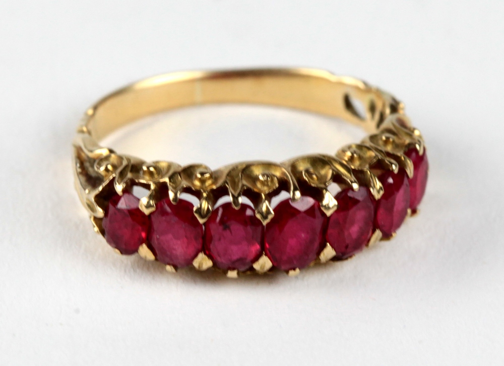 An attractive gold Ladies Ring, inset with seven ruby type graduating stones.