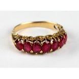 An attractive gold Ladies Ring, inset with seven ruby type graduating stones.