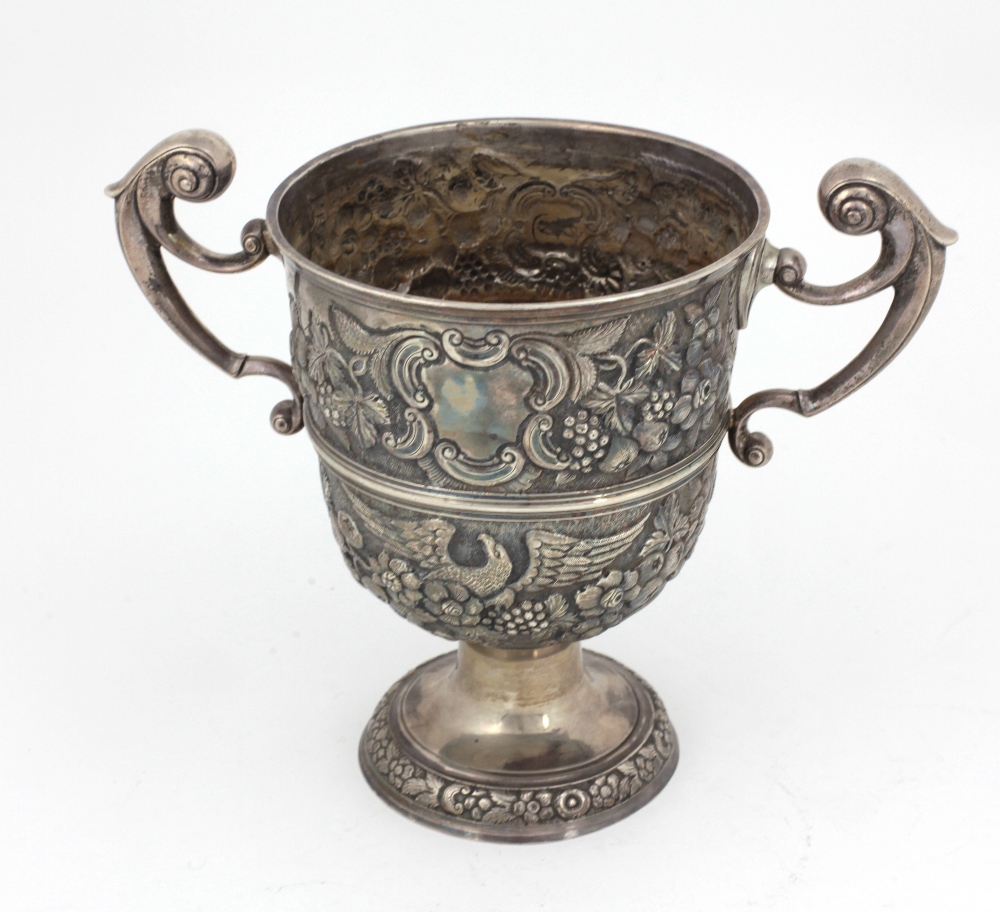 An 18th Century Irish silver two handled Cup, with repoussé decoration depicting eagles, fruit,