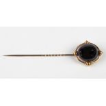 An attractive gold Tie Pin, with oval ruby type stone decorated in Celtic taste, by John D.