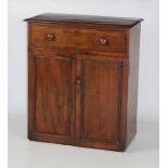 A mahogany Cupboard, of low proportions, the moulded top over frieze drawer with two panelled doors.
