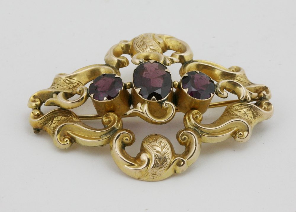 A 9ct gold Brooch, with three rhodolite garnets.